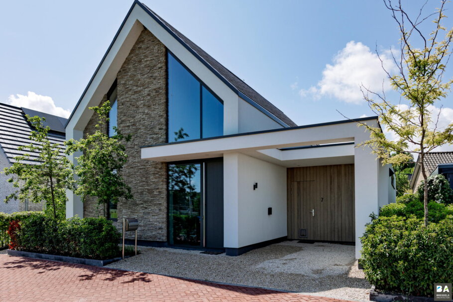 Moderne woning met hoge glazen achtergevel en schuifpuien