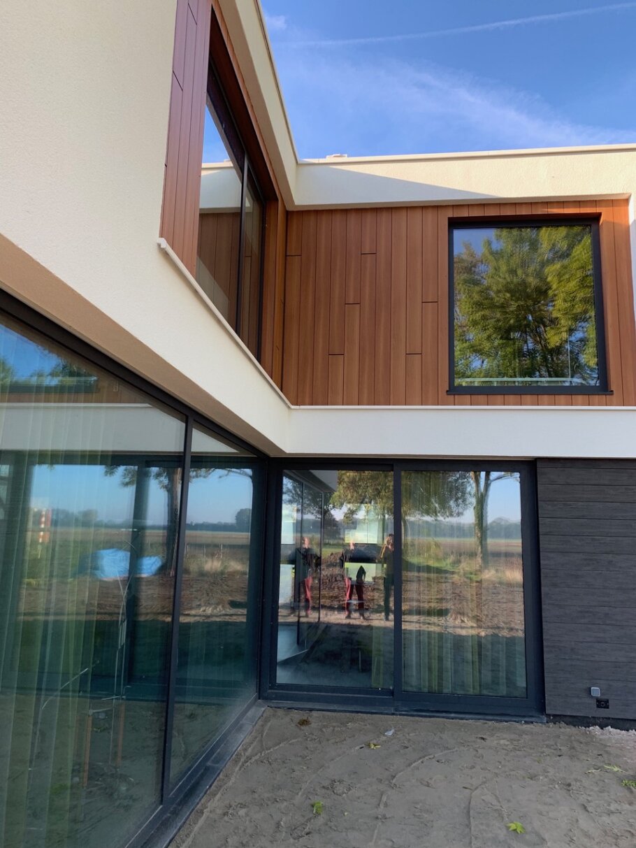 Moderne woning met hoge glazen achtergevel en schuifpuien