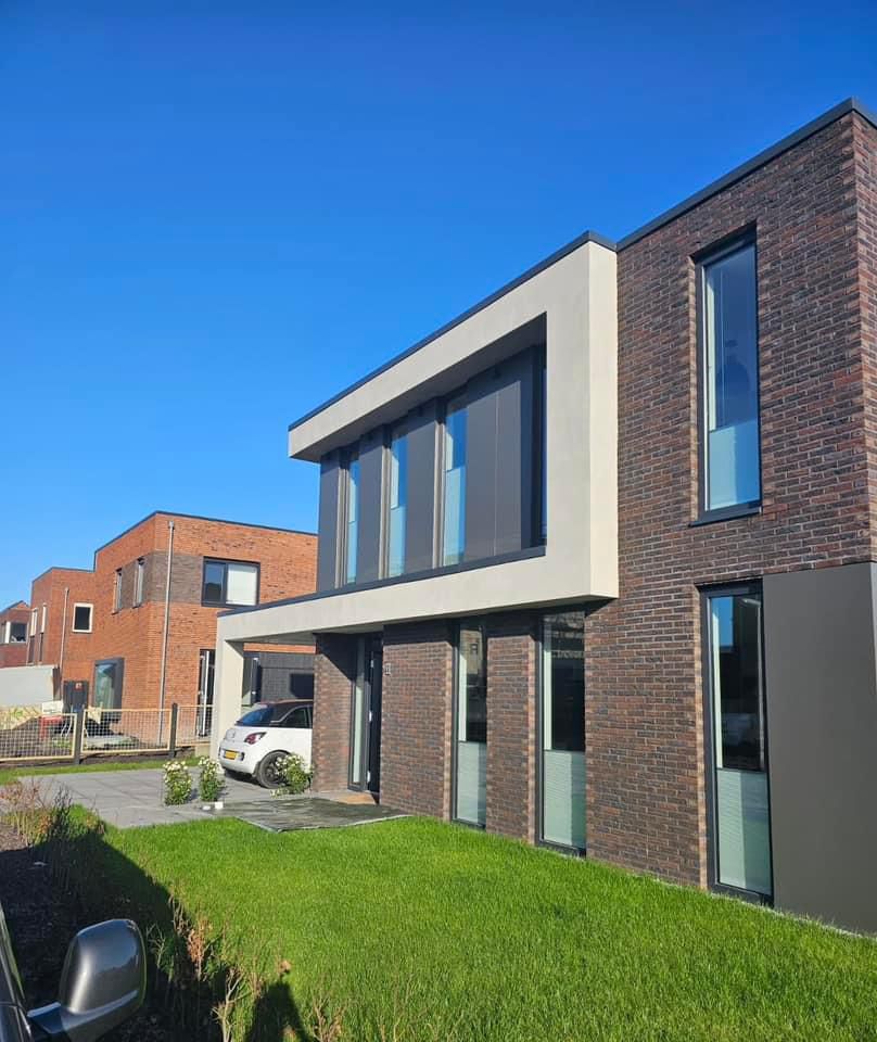 Moderne woning met hoge glazen achtergevel en schuifpuien