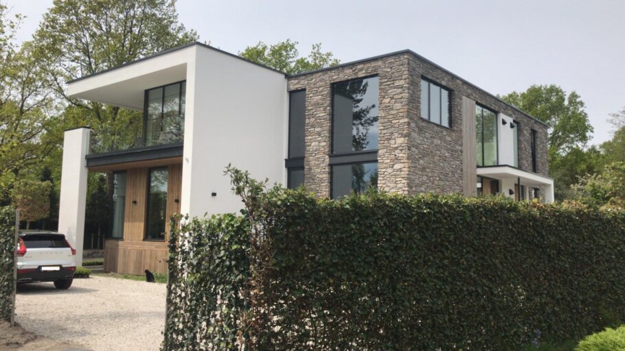 Moderne woning met hoge glazen achtergevel en schuifpuien