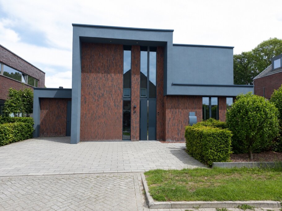Moderne woning met hoge glazen achtergevel en schuifpuien