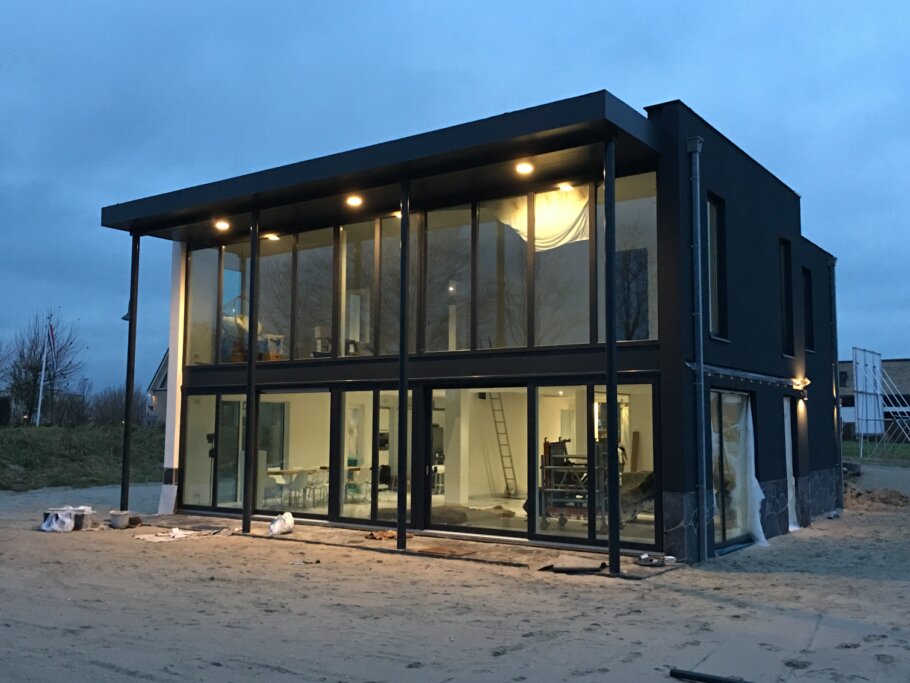 Moderne woning met hoge glazen achtergevel en schuifpuien